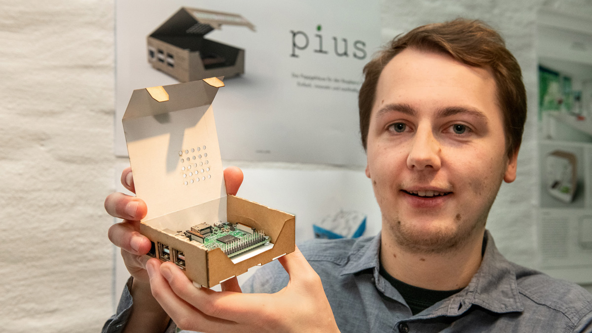 Student hält Gehäuse aus Karton für Computer "Rasperry Pi"