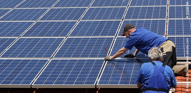 Handwerker auf Dach mit Photovoltaikanlage