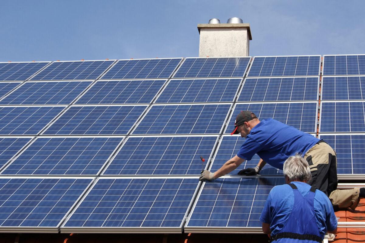 2 Männer installieren eine PV-anlage auf dem Dach