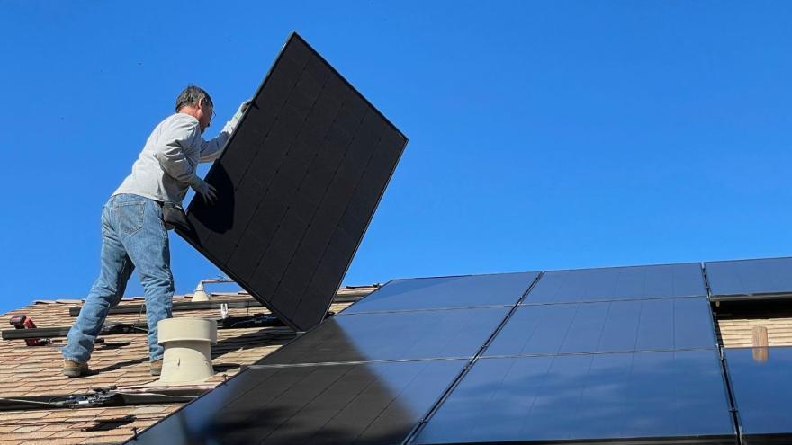 Handwerker bringt Solarpaneel auf Dach an