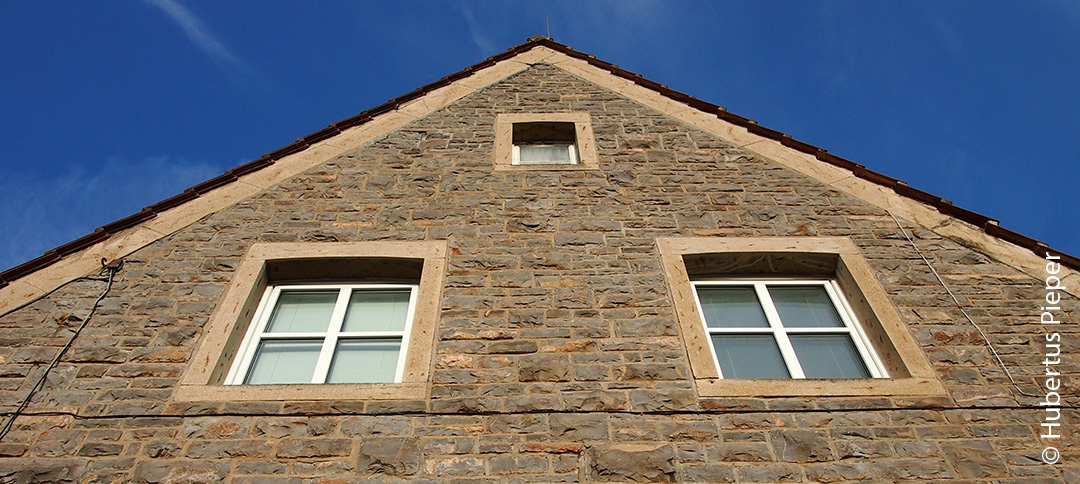 Hauswand mit 3 Fenstern von unten fotografiert