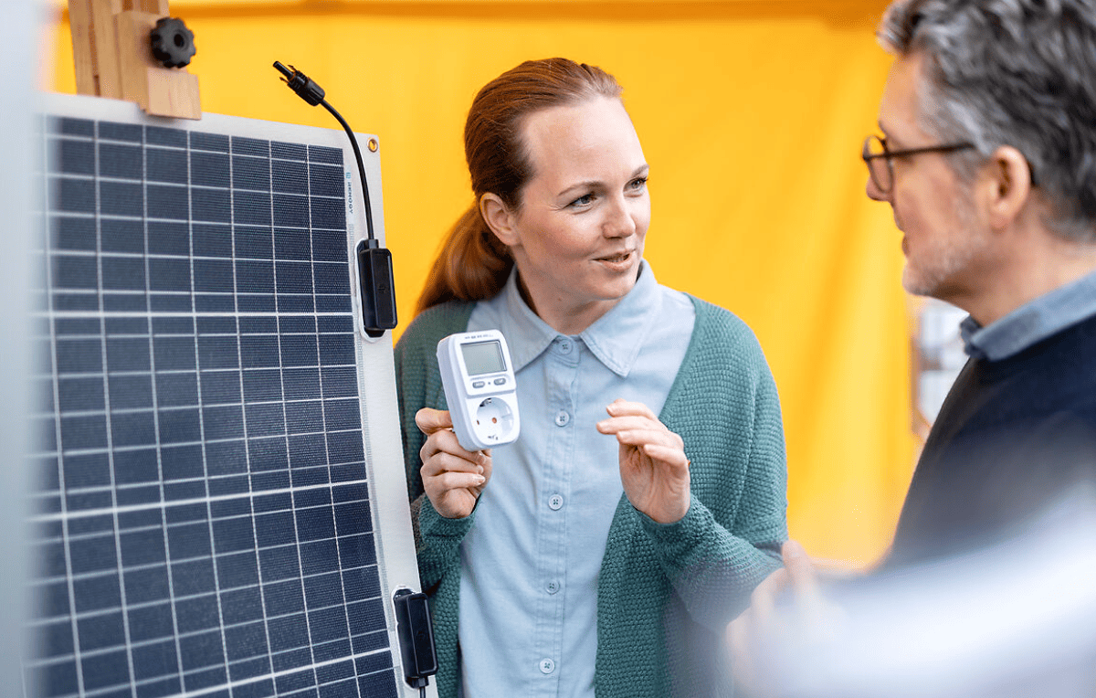 Beratungssituation vor einem Steckersolarmodul