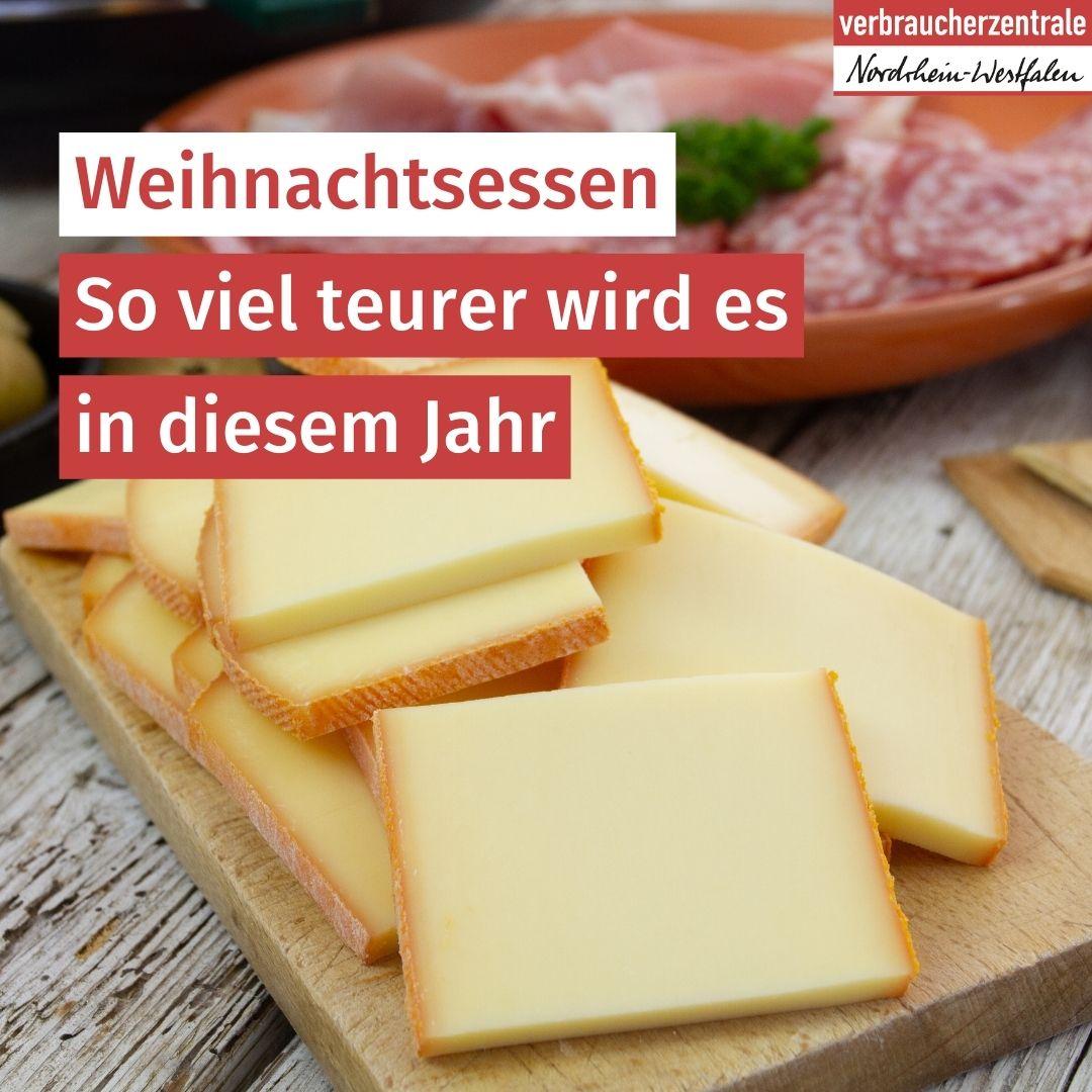 Holzbrett mit Raclettekäse im Vordergrund, Teller mit Wurst im Hintergrund, darüber Text: "Weihnachtsessen - So viel teurer wird es in diesem Jahr."