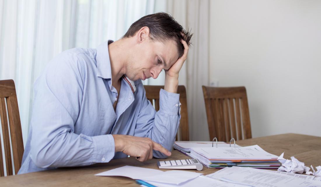 Verzweifelter Schuldner mit Unterlagen