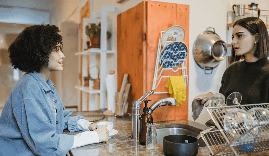 Zwei junge Frauen unterhalten sich in Küche