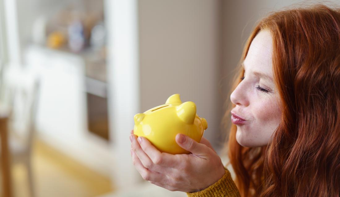 Frau küsst Sparschwein