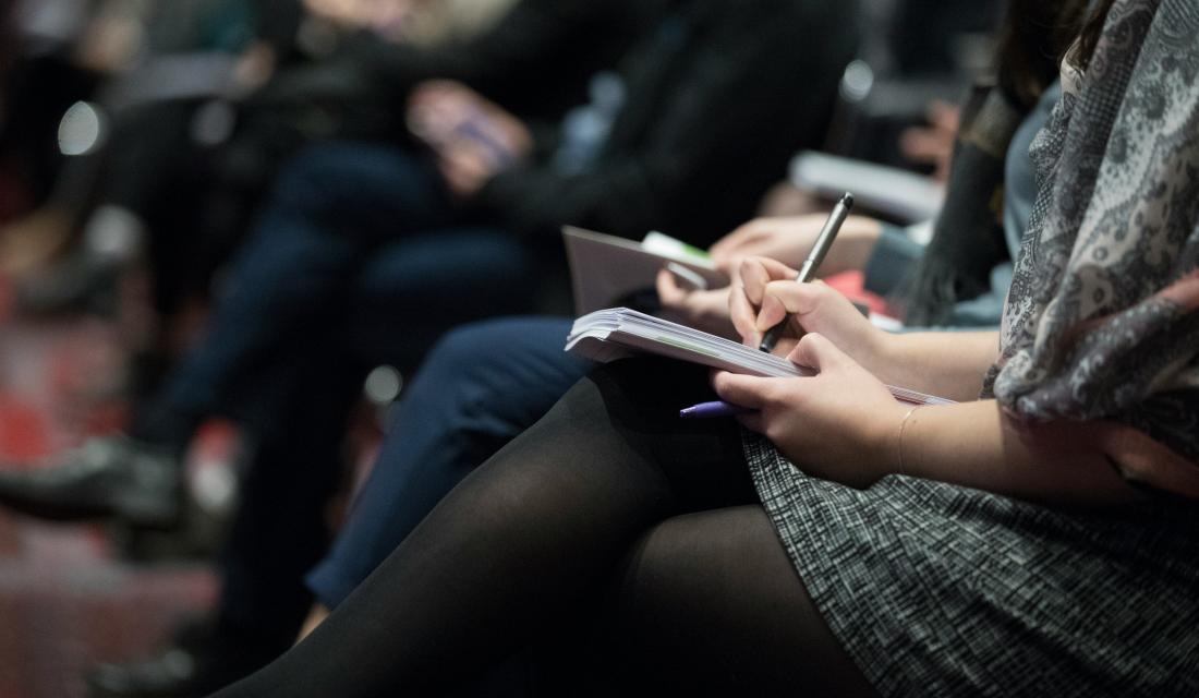 Menschen sitzen nebeneinander und schreiben mit