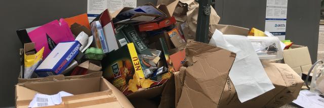 Papiermüll vor einem Altpapiercontainer