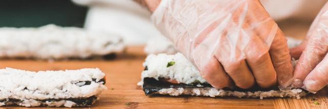 Ein Mann bereitet frisches Sushi zu