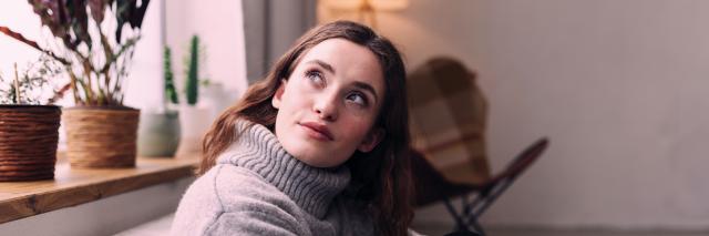 Frau lehnt an Heizung