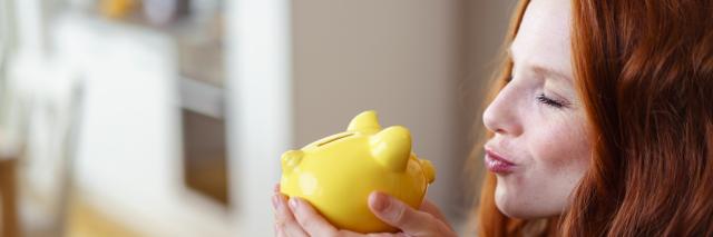 Frau küsst Sparschwein