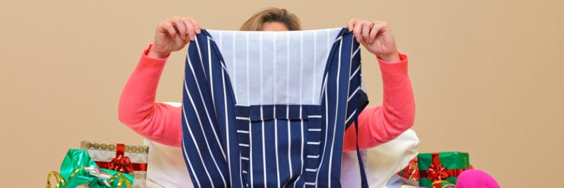 Frau hält geschenkte Schürze hoch