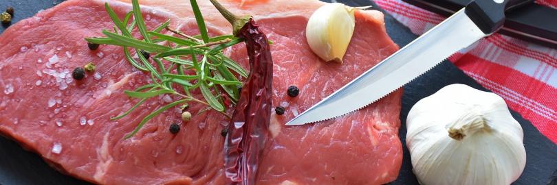 Rohes Steak mit Gewürzen, Knoblauch und Tomaten dekoriert