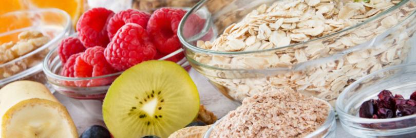 Obst, Nüsse und Müsli stehen auf einem bunt gedeckten Tisch