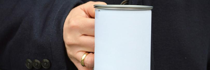 Hand mit Spendendose vor schwarzem Mantel