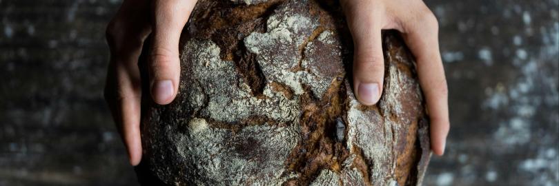 Ein Brot wird in zwei Händen gehalten