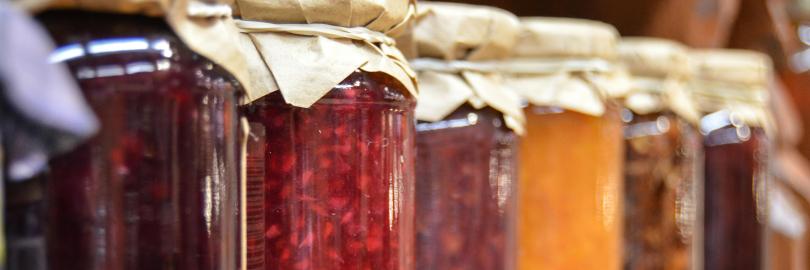 Verschiedene Marmeladengläser nebeneinander aufgereiht