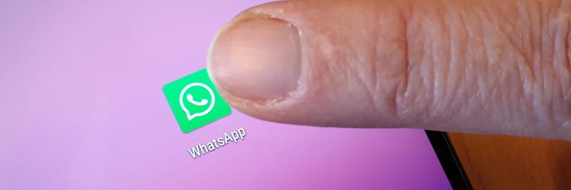 Ein Finger tippt aufs WhatsApp-Logo auf einem Smartphone-Display