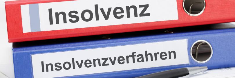 Zwei übereinander liegende Aktenordner, einer mit der Aufschrift Insolvenz, einer mit Insolvenzverfahren