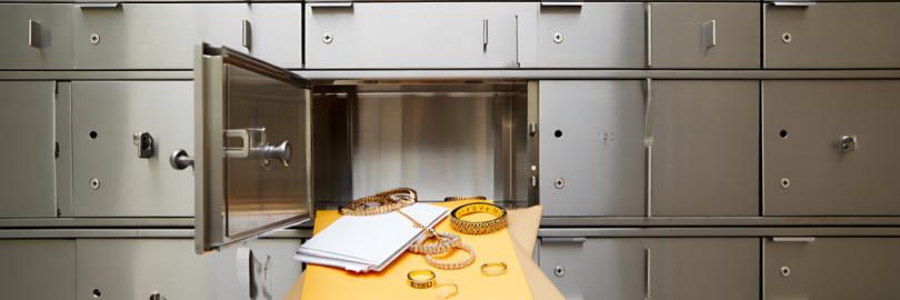 Geöffnetes Bankschließfach, aus dem Wertgegenstände herausragen