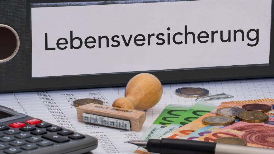 Aktenordner mit Stempel, Geld und Stift