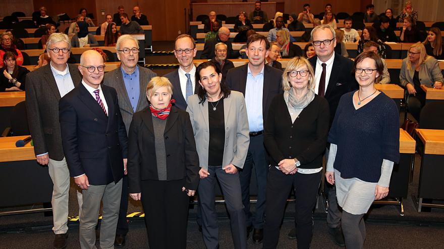 Zehn Personen stehen in zwei Reihen.
