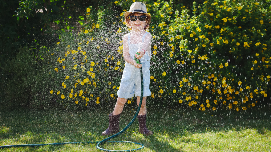 Junge mit Wasserschlauch