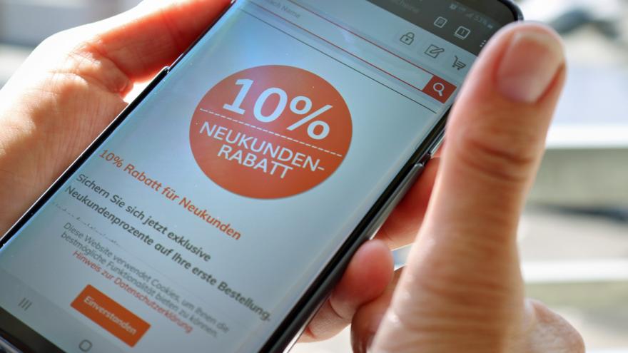 Zwei Hände mit Smartphone und Display-Aufschrift "10 % Neukundenrabatt"