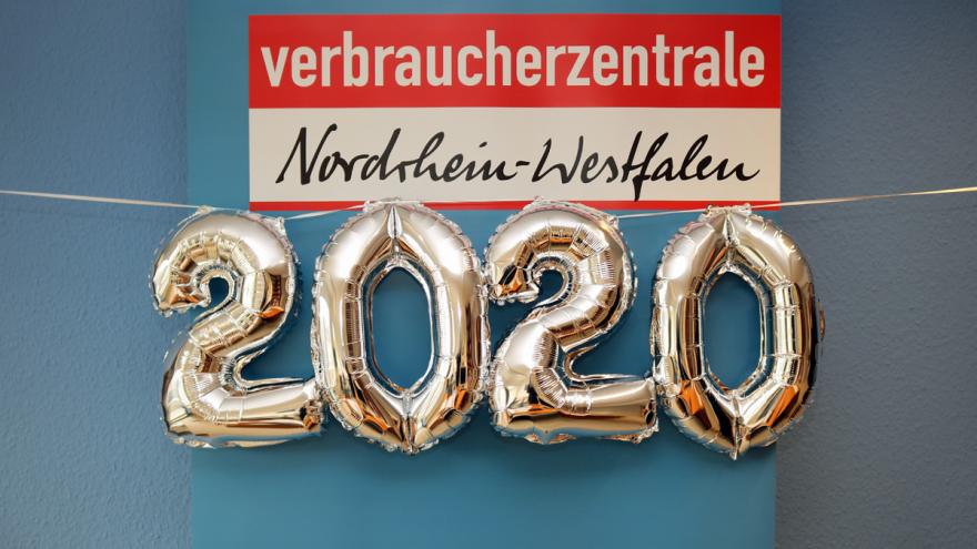 Luftballons formen die Jahreszahl 2020 unter dem Logo der Verbraucherzentrale NRW