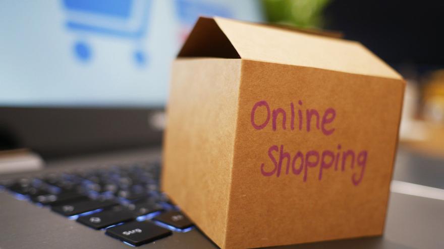 Kleines Paket mit Aufschrift "Online Shopping" auf Laptop-Tastatur