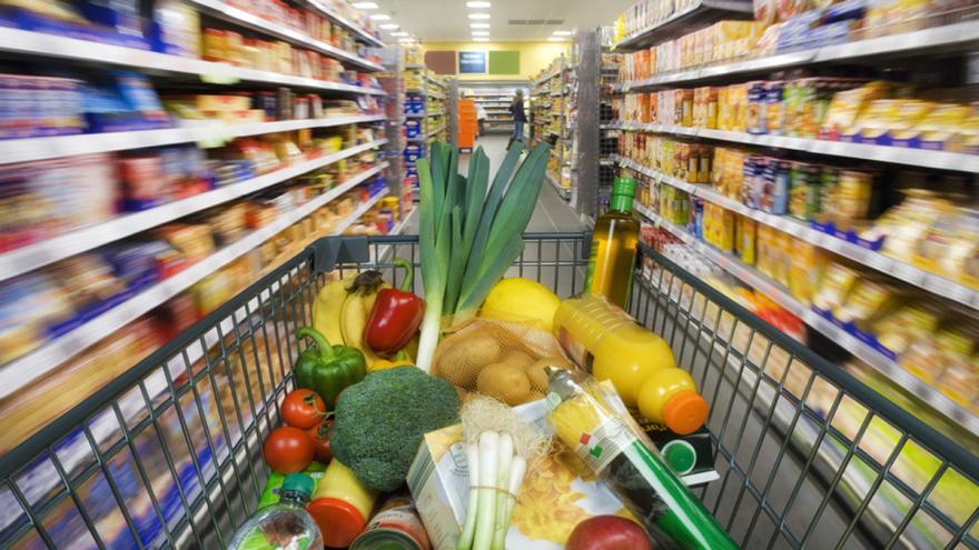 Gefüllter Einkaufswagen in Supermarktgang