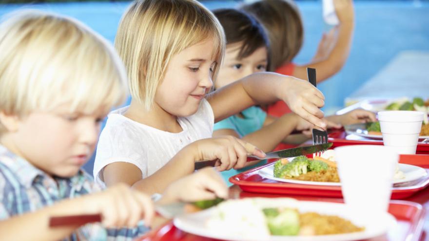 Kinder sitzen an einem Tisch und essen