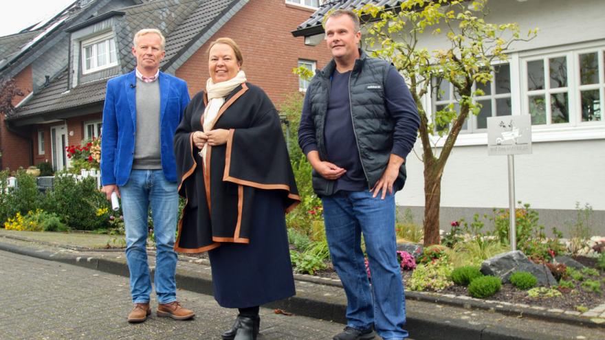 Drei Personen vor einem Vorgarten (von links): Udo Sieverding, Bereichsleiter Energie der Verbraucherzentrale NRW, Ursula Heinen-Esser, Ministerin für Umwelt, Landwirtschaft, Natur- und Verbraucherschutz des Landes NRW, Torsten Brämer, Gartenbesitzer.