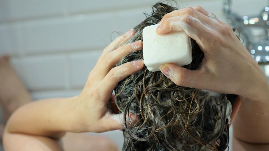 Frau wäscht sich die Haare mit fester Shampooseife