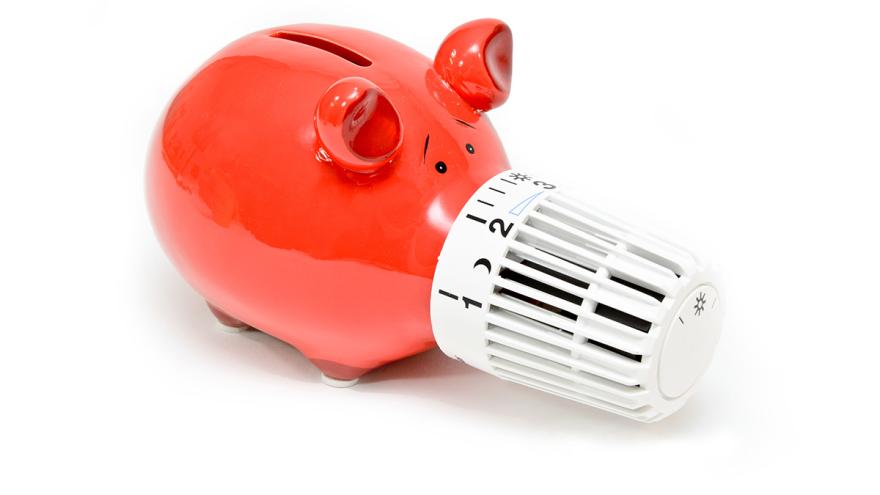Rotes Sparschwein mit Thermostat auf der Nase