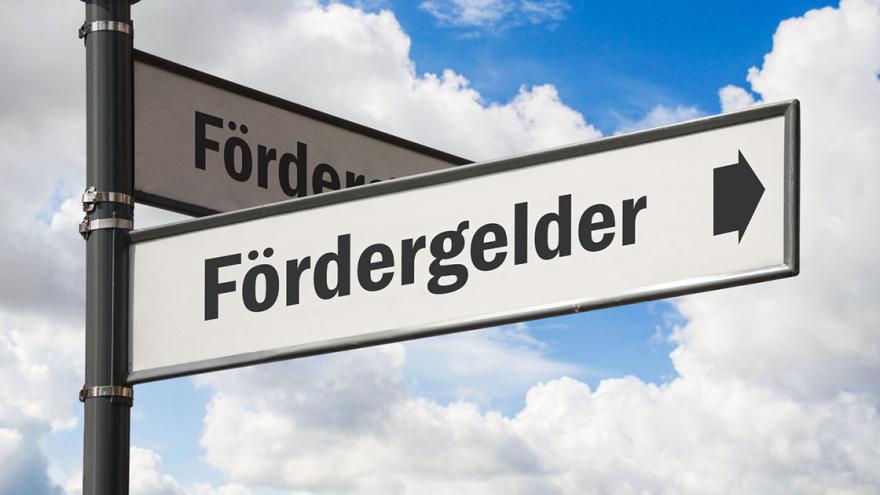 Straßenschild mit Pfeil Richtung "Fördergelder"
