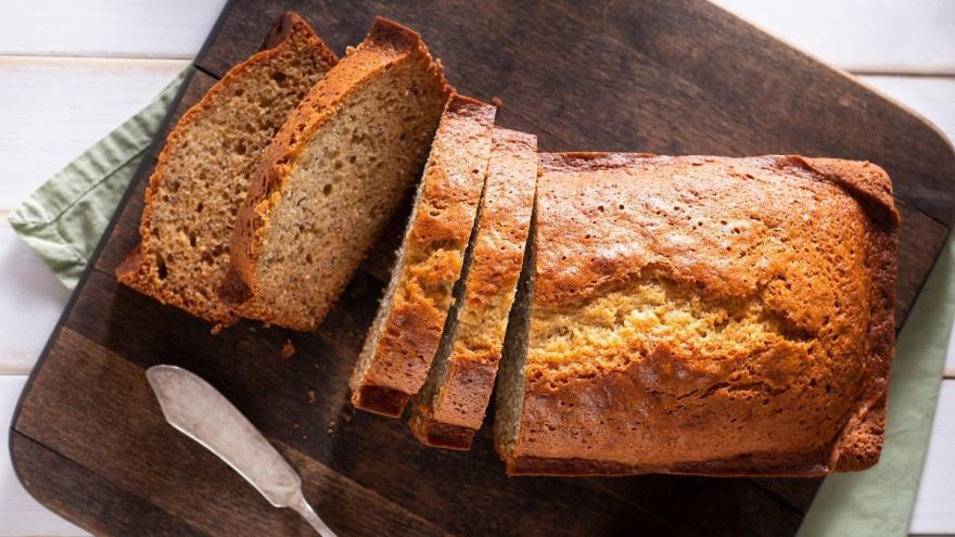 Bananenbrot liegt geschnitten auf einem Holzbrett