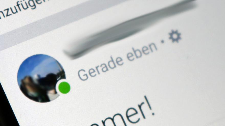 Ein grüner Punkt am Profilbild eines Facebook-Nutzers schräg von einem PC-Bildschirm fotografiert