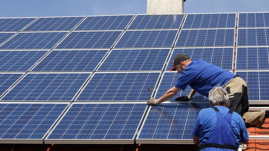 Handwerker montieren PV-Anlage auf Hausdach