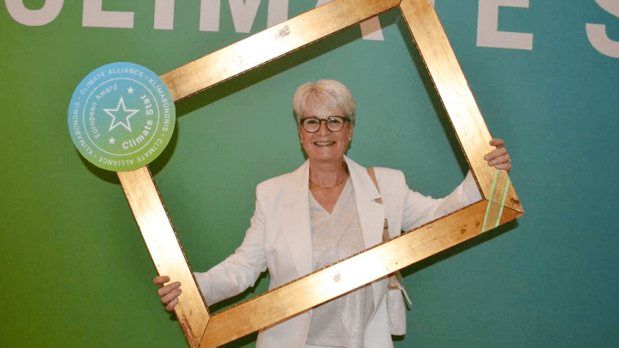 Energieberaterin Susanne Berger posiert mit dem goldenen Fotorahmen des Climate Star Awards 2025