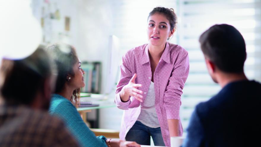 Frau erklärt anderen in einer Sitzung etwas