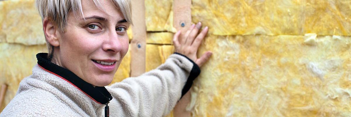 Junge Frau vor frisch gedämmter Wand