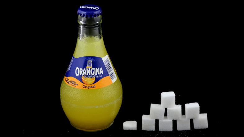 Glasflasche Orangina und Zuckerwürfel-Pyramide
