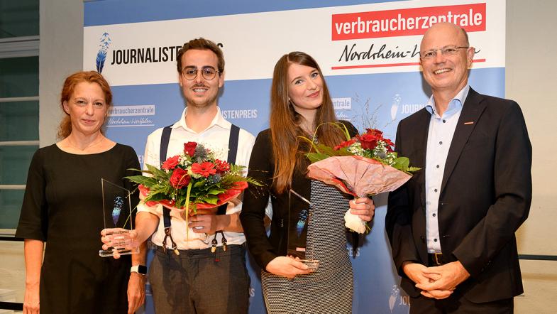 Prof. Dr. Barbara Brandstetter, Lucas Tenberg, Jana Heck und Wolfgang Schuldzinski (von links) stehen auf einer Bühne und lächeln in die Kamera