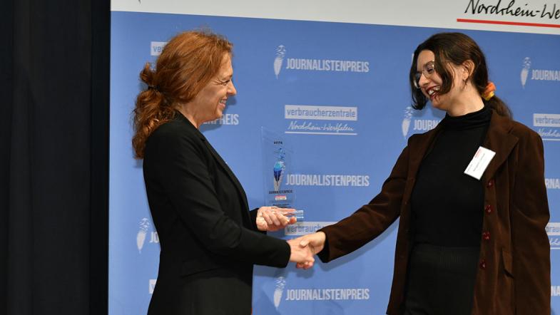 Jurymitglied mit Gewinnerin auf der Bühne