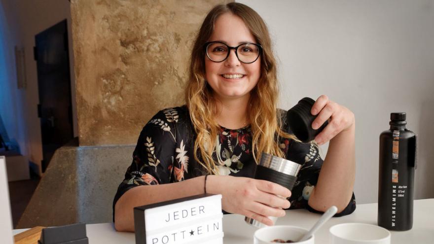 Studentin mit Becher und einem To-Go-Deckel