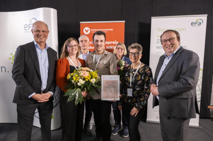 Gruppe mit Gewinnern posiert bei der Preisverleihung vor Banern