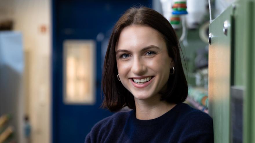 Eine Frau mit dunklen schulterlangen Haaren lächelt in die Kamera