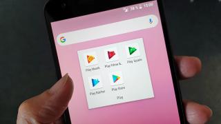 Hand hält Smartphone mit App-Icons von Google Play