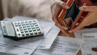 Hände mit Geldbörse und Taschenrechner von Rechnungen